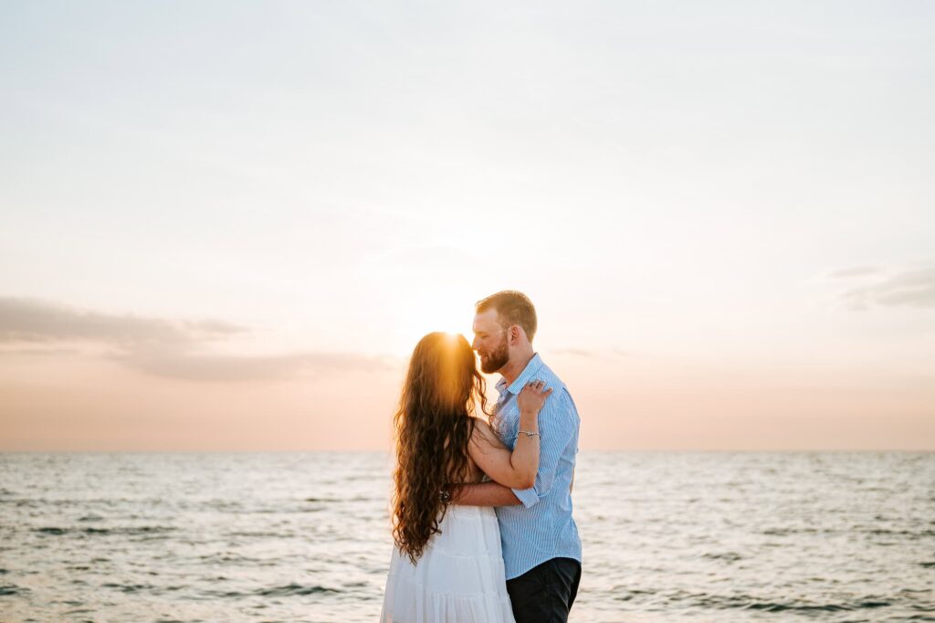 Sunset silhouettes of a newly engaged couple on Sand Key Beach captured by Atlanta destination wedding photographer Peach State Weddings