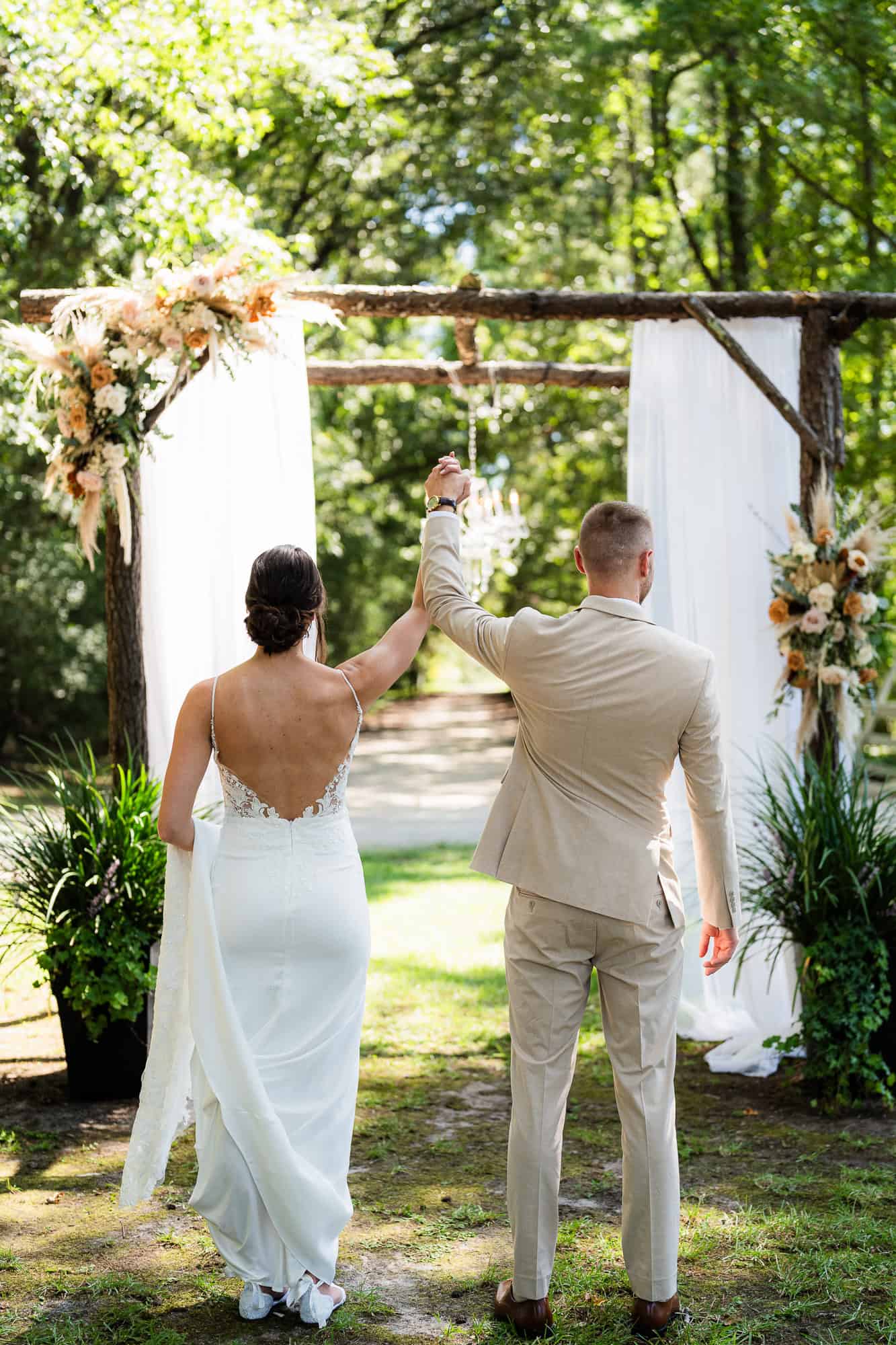 bride and groom back at the ceremony site, just celebrating that all the wedding planning stress is over and they can just enjoy their big day