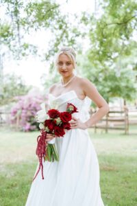 Lucy in her timeless white wedding gown holding her wedding bouquet with red and white roses photographed by Atlanta Wedding photographer in Lakeland Florida.