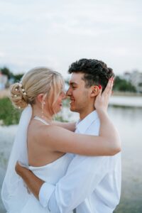 Golden hour wedding portraits of a bride and groom at the Lake Mirror Loggia, showcasing the historic white stone arches in Lakeland, FL.