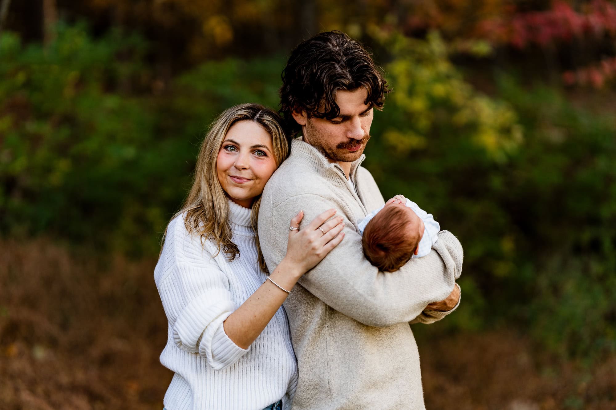 New parents Zach and Hannah sharing a quiet moment with their baby at Kennesaw Mountain during fall golden hour, Kennesaw photographer