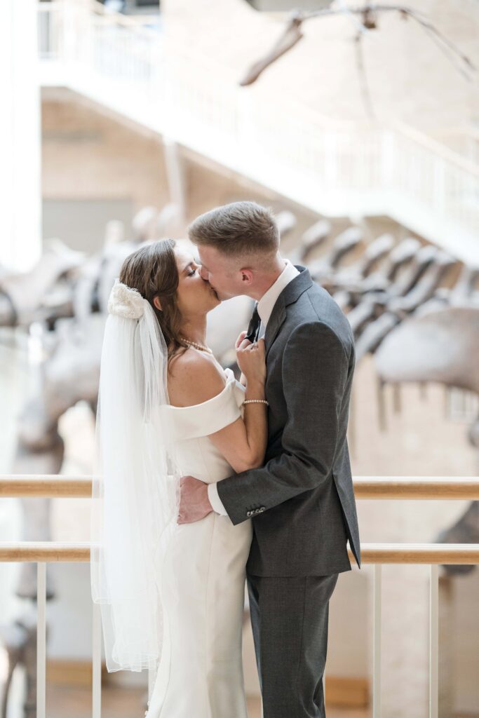 Atlanta Wedding Photographer at the Fernbank Museum a premier Atlanta wedding venue capturing wedding Couple kissing