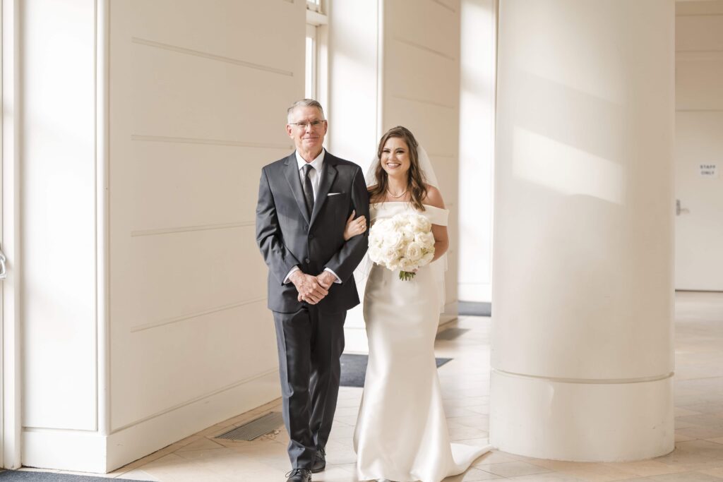 Father is walking his daughter down the aisle at the Fernbank Museum. Photographed by Georgia Wedding Photographer. Timeless wedding photography in Atlanta GA.