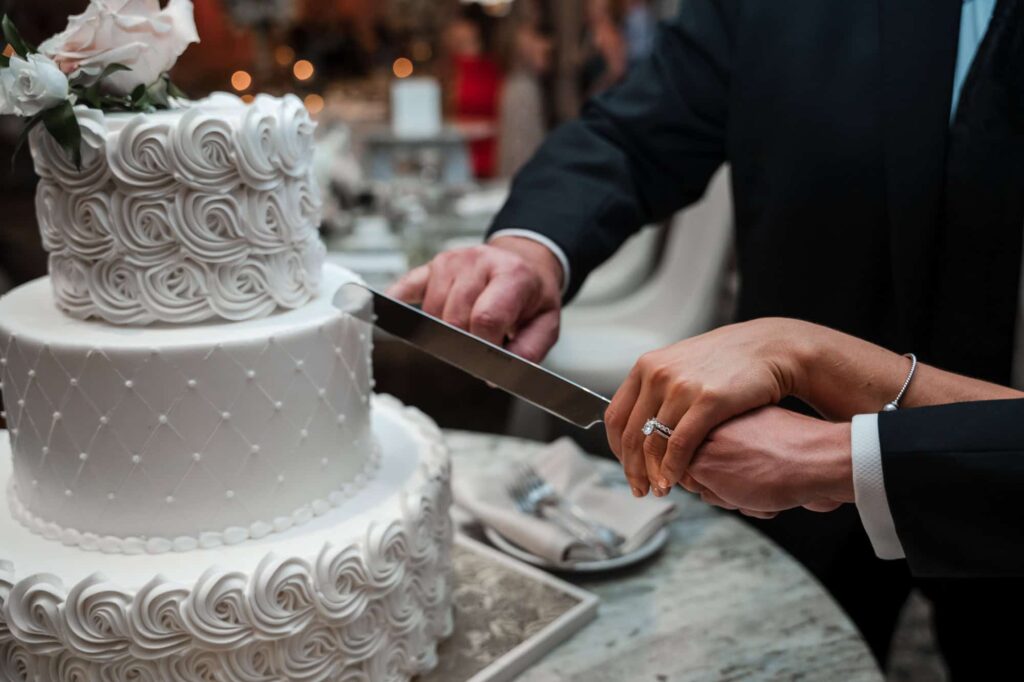 the couple is cutting the cake at the Rockleigh wedding venue in Rockleigh, NJ, captured by Atlanta wedding photographer Peach State Weddings