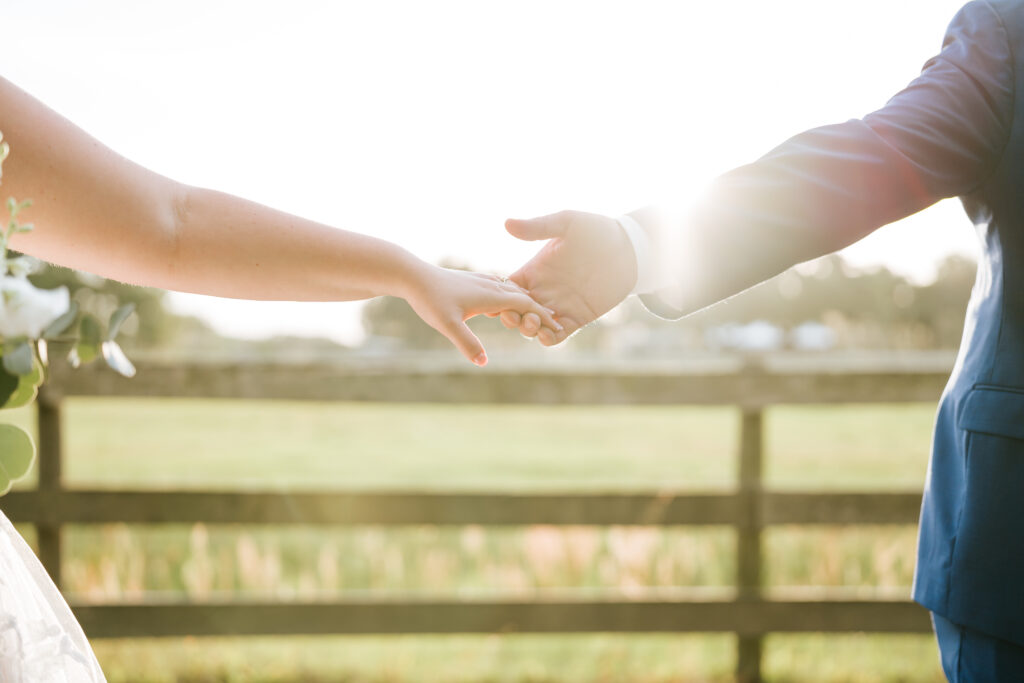 Portfolio 12 the couple's fingertips are touching during their golden hour portraits