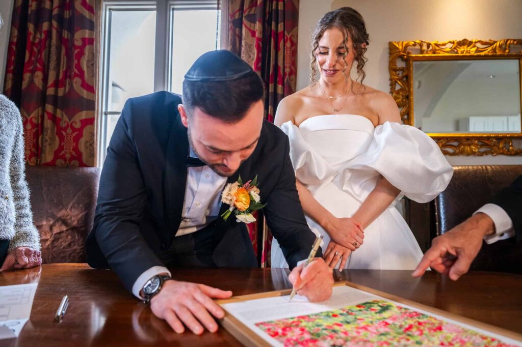 groom signs the Ketubah - the jewish marriage contract between husband and wife.