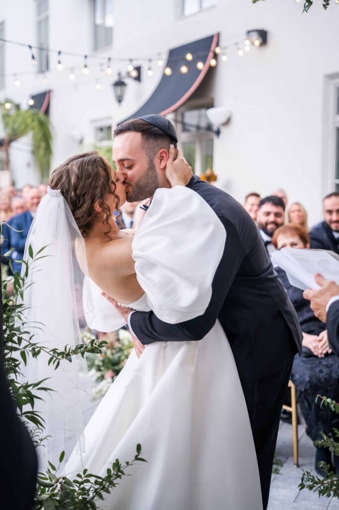 Groom kisses his bride for the first time - Jewish wedding ceremony at Casa Monica Resort in St Augustine Florida. Photographed by Atlanta Wedding Photographer Peach State Weddings