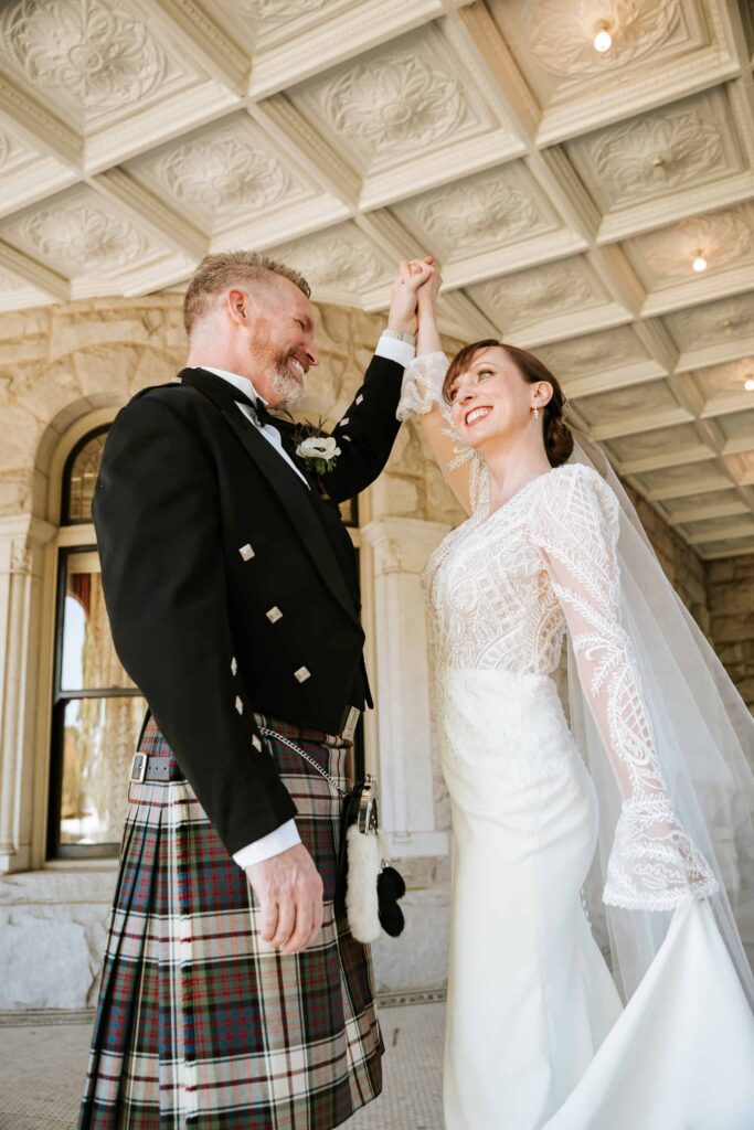 Bride and groom dancing under the ornate coffered ceilings of the Rhodes Hall veranda in Atlanta.