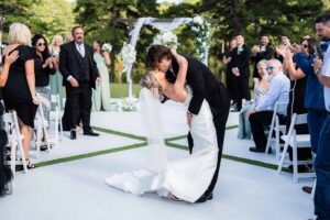 Groom dips the bride in the middle of the aisle and kisses her - one epic moment captured by Peach State Wedding photographer in South Georgia at The Venue at Daisy Hill