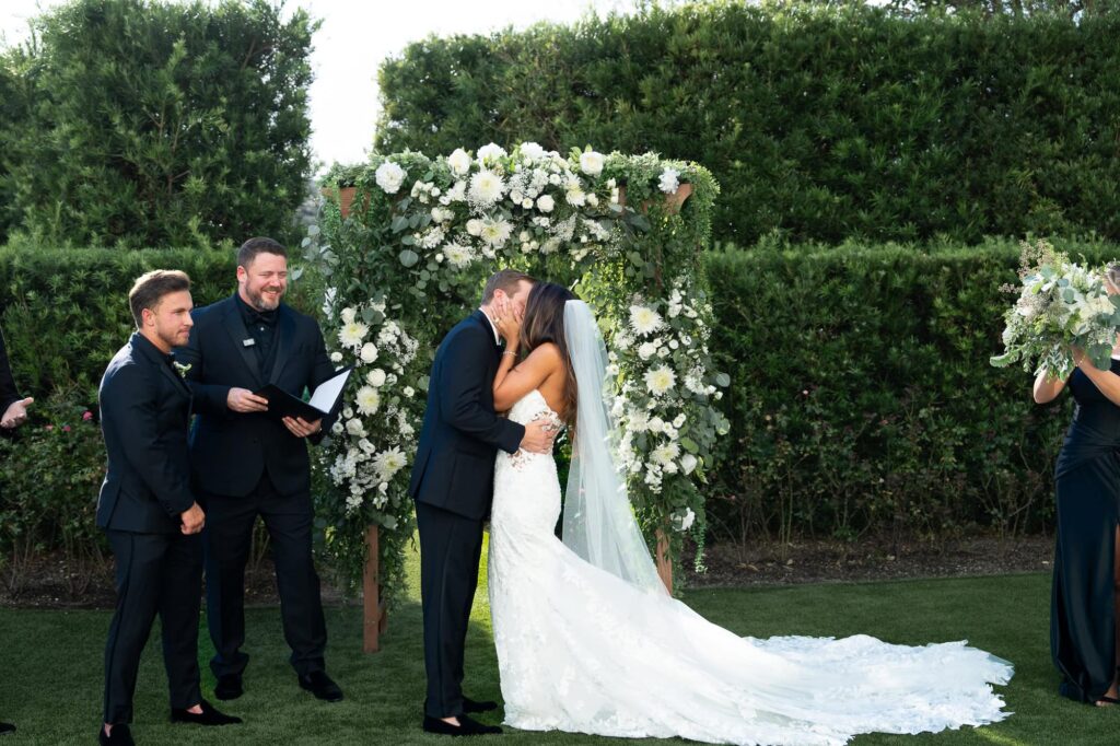 	Atlanta Georgia wedding photographer captures a bride and groom's first kiss in the lush rose garden at the World Equestrian Center.
