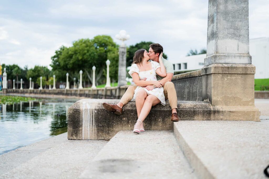 Atlanta wedding photographer Peach State Weddings captures engagement session at Lake Mirror in Lakeland Florida. Couple looking at each other while sharing an intimate moment right by the lake
