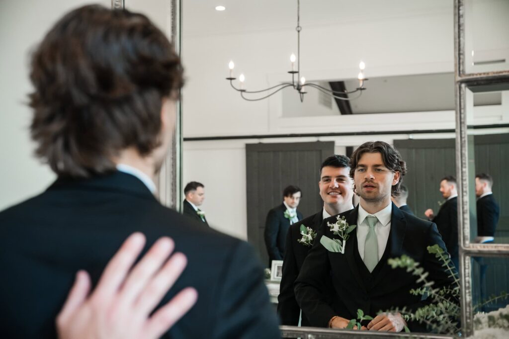Groom getting ready at the grooms suite at the venue at daisy Hill - wedding photographers in Fayetteville, GA