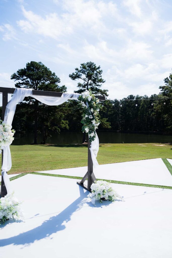 Full view of the outdoor ceremony altar at The Venue at Daisy Hill, showing the peaceful pond and surrounding Georgia pines.