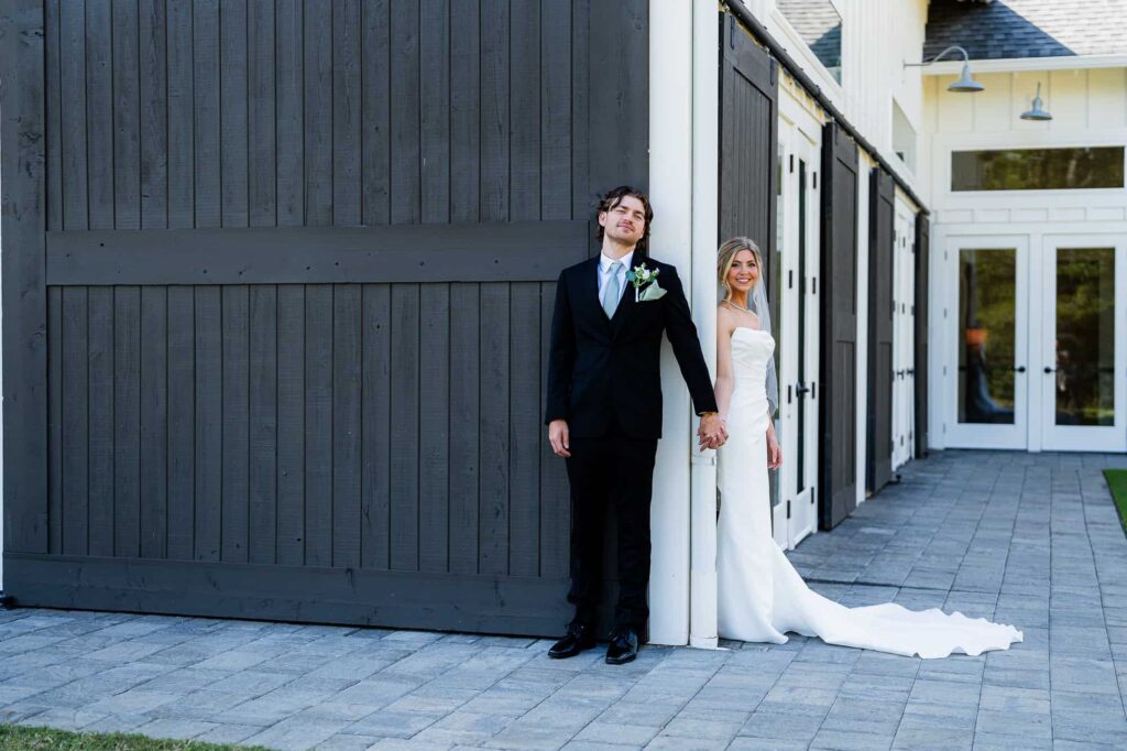 Bride and groom holding hands around a corner for a first touch at Daisy Hill; captured by Peach State Weddings, Atlanta wedding photographer.