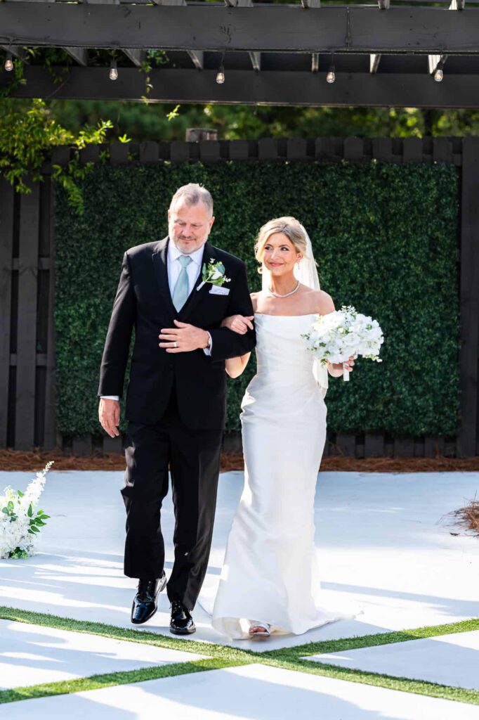 Hannah walking down the aisle with her father at The Venue at Daisy Hill; emotional family moments in Georgia.