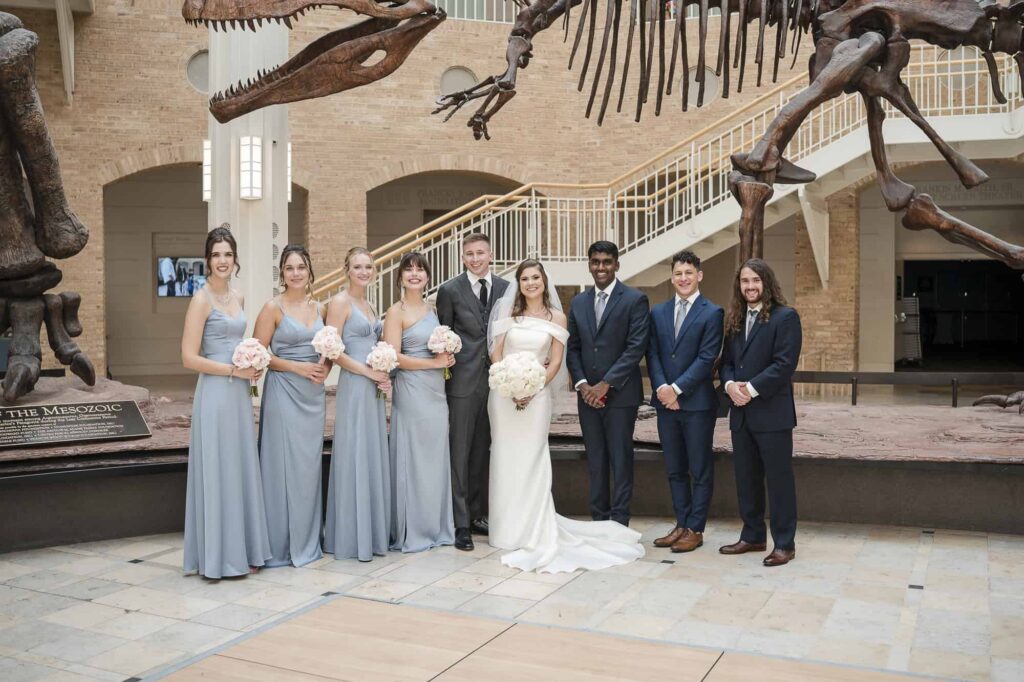 Atlanta wedding photographer captures wedding formals - bride and groom pose with bridesmaids and groomsmen in the great hall of the fernbank museum in Atlanta 