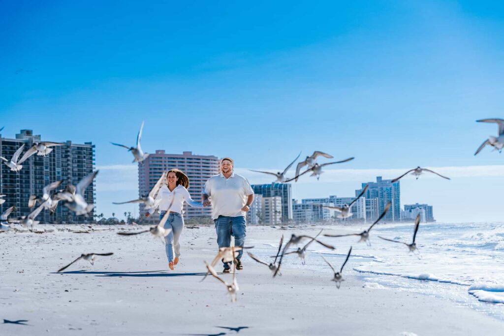 Sand Key Beach is a hidden gem when it comes to engagement sessions and proposals. Couple running along the beach. captured by Atlanta photographer