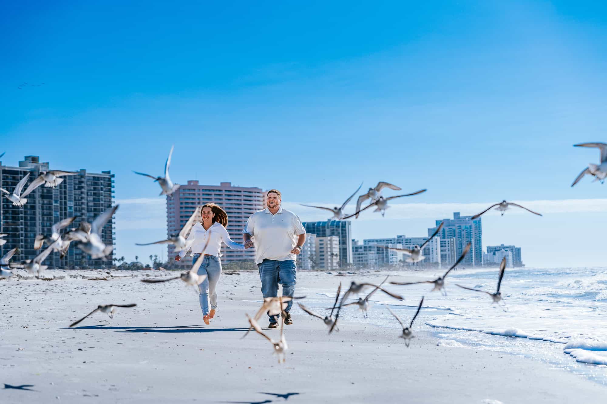 Sand Key Beach is a hidden gem when it comes to engagement sessions and proposals. Couple running along the beach. captured by Atlanta photographer